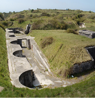 An overhead view of High Angle Battery - a large concrete trench structure with circular areas set into the grassy banks 